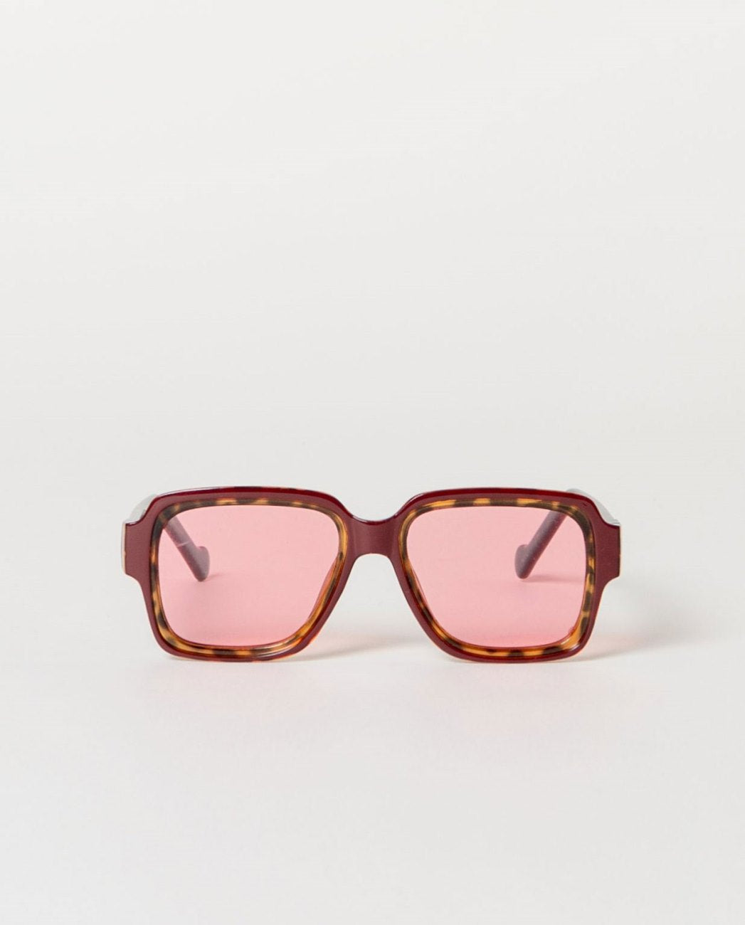 Sunglasses with tortoiseshell maroon frame and pink lenses.