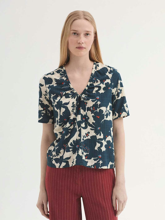 Ecru top in sustainable viscose fabric, Penelope Flowers print in blue and small orange dots, with V neck, self-fabric tie for gathering and short sleeves.