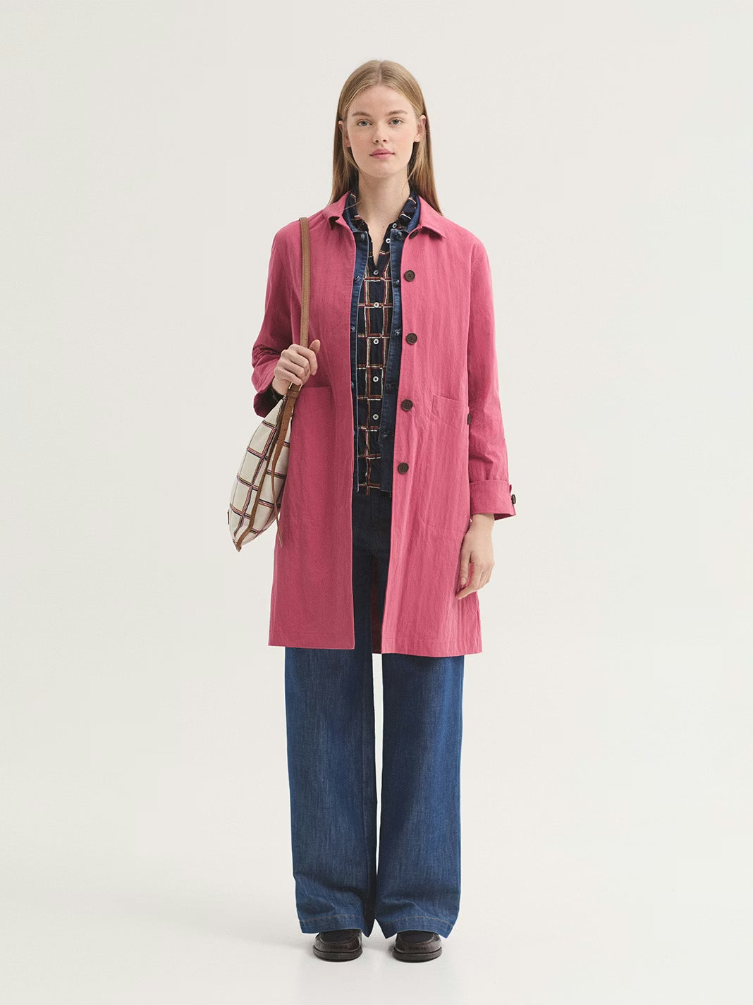 Water-resistant intense pink trench coat made of cotton and nylon blend. Featuring a shirt collar, concealed button front and pockets with button. With vent and button at back, and sleeves with folded cuff and button.
