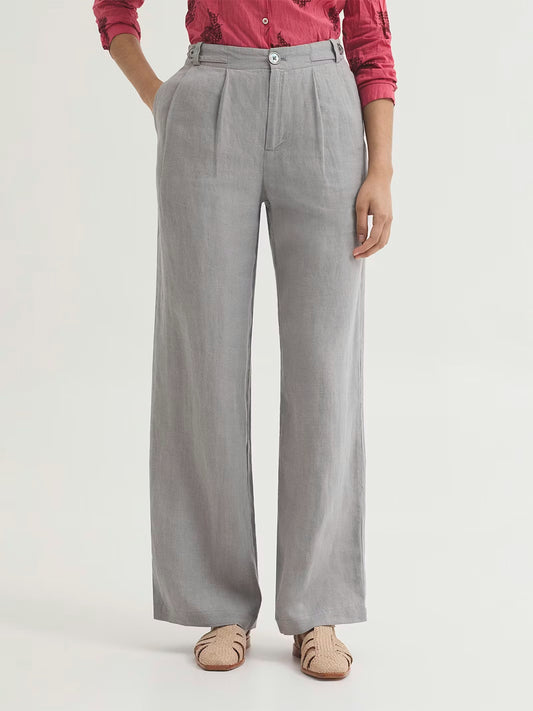 Darted light grey trousers made of 100% linen fabric. Zip and mother-of-pearl button fastening at front. Waistband with loops and buttons. With side pockets and an ironed-in crease.