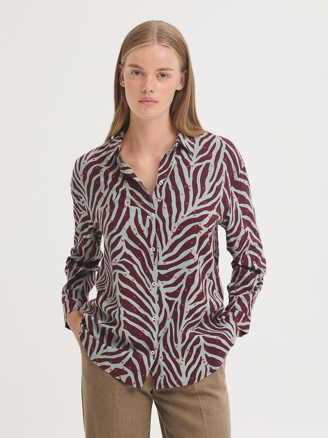 Shirt with Zebra print in sustainable viscose fabric, in granite green background color and bordeaux zebra print color with red spots, shirt collar and mother-of-pearl button front, long sleeves with cuff and button, loose fit.
