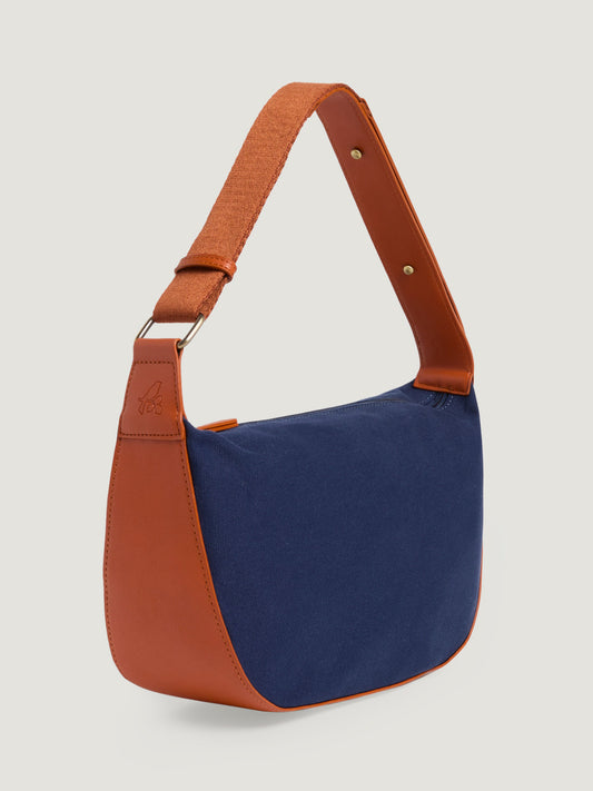 Gondola style canvas blue navy shoulder bag with adjustable strap. Zip fastening. Inside pockets. Patch logo. 35 cm wide x 23 cm tall x 10 cm deep.   Composition: 65% Cotton 35% Polyurethane