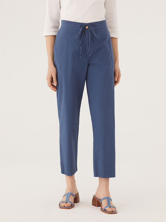 Cotton poplin, light blue trousers. Side seam pockets. Front zip and button. Belt for gathering and concealed elasticated back.  Composition: 100% Cotton